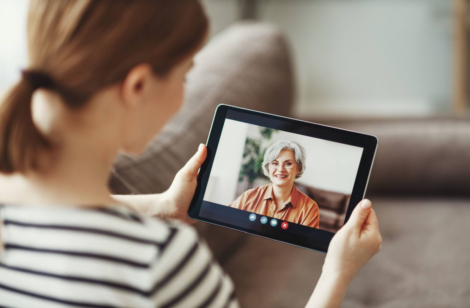 An older adult woman on a video call with a family member.