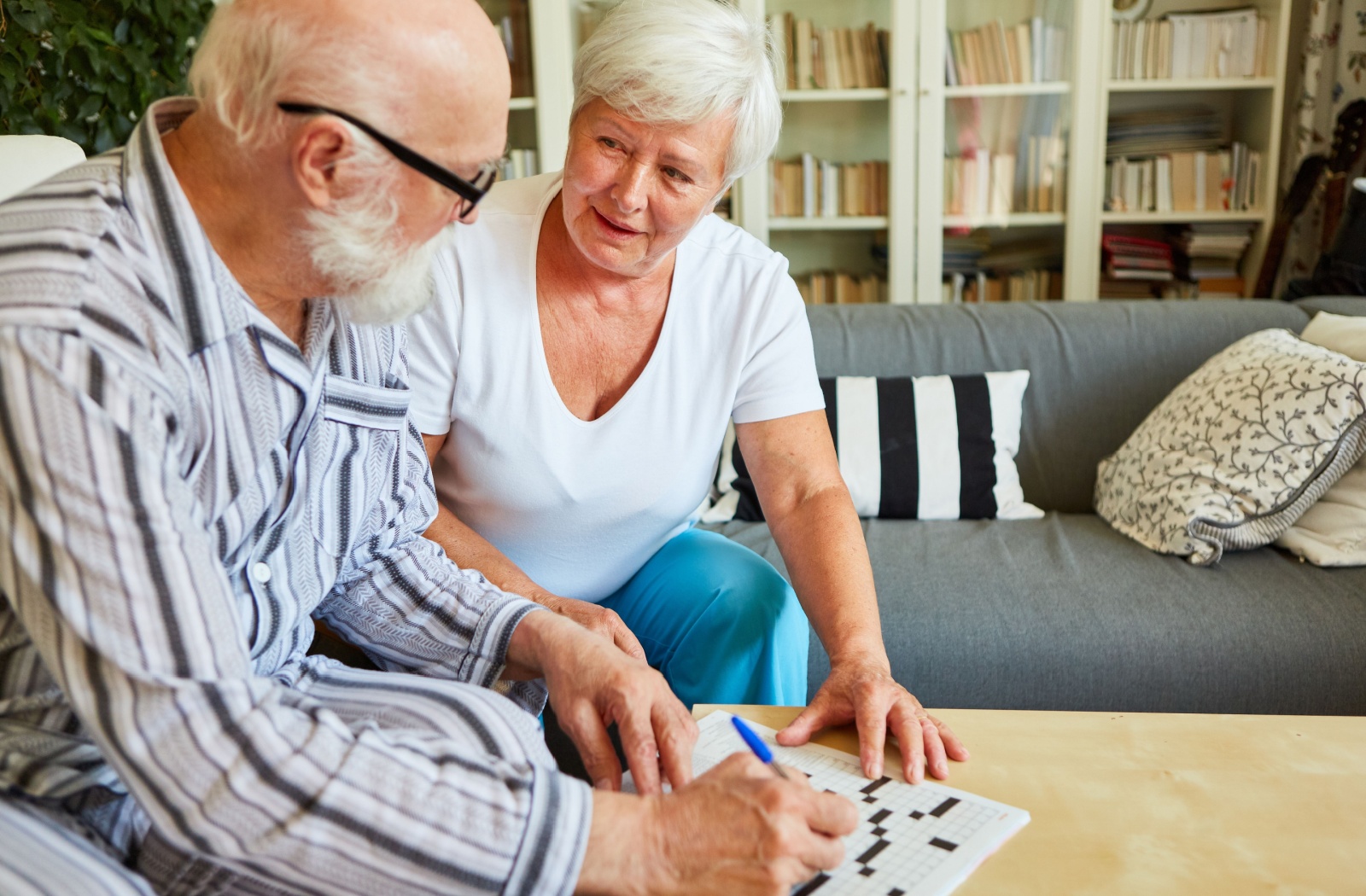 A couple strengthens their cognitive health and keeps their minds sharp by enjoying crossword puzzles together.
