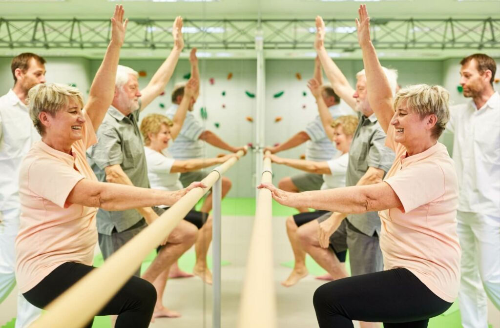 A group of seniors perform balance exercises under the guidance of a physical therapist in assisted living to improve balance